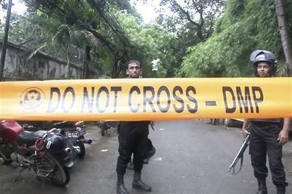 Bangladeshi security forces block the road after militants took hostages.