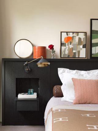 Bedroom with black wooden headboard with built in storage