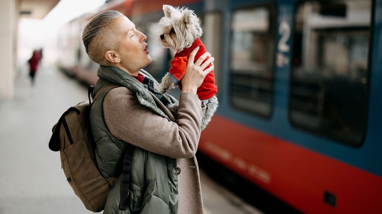 Portrait of a woman and a dog waiting for a train