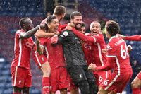 Liverpool's Brazilian goalkeeper Alisson Becker celebrates scoring his team's second goal with teammates.