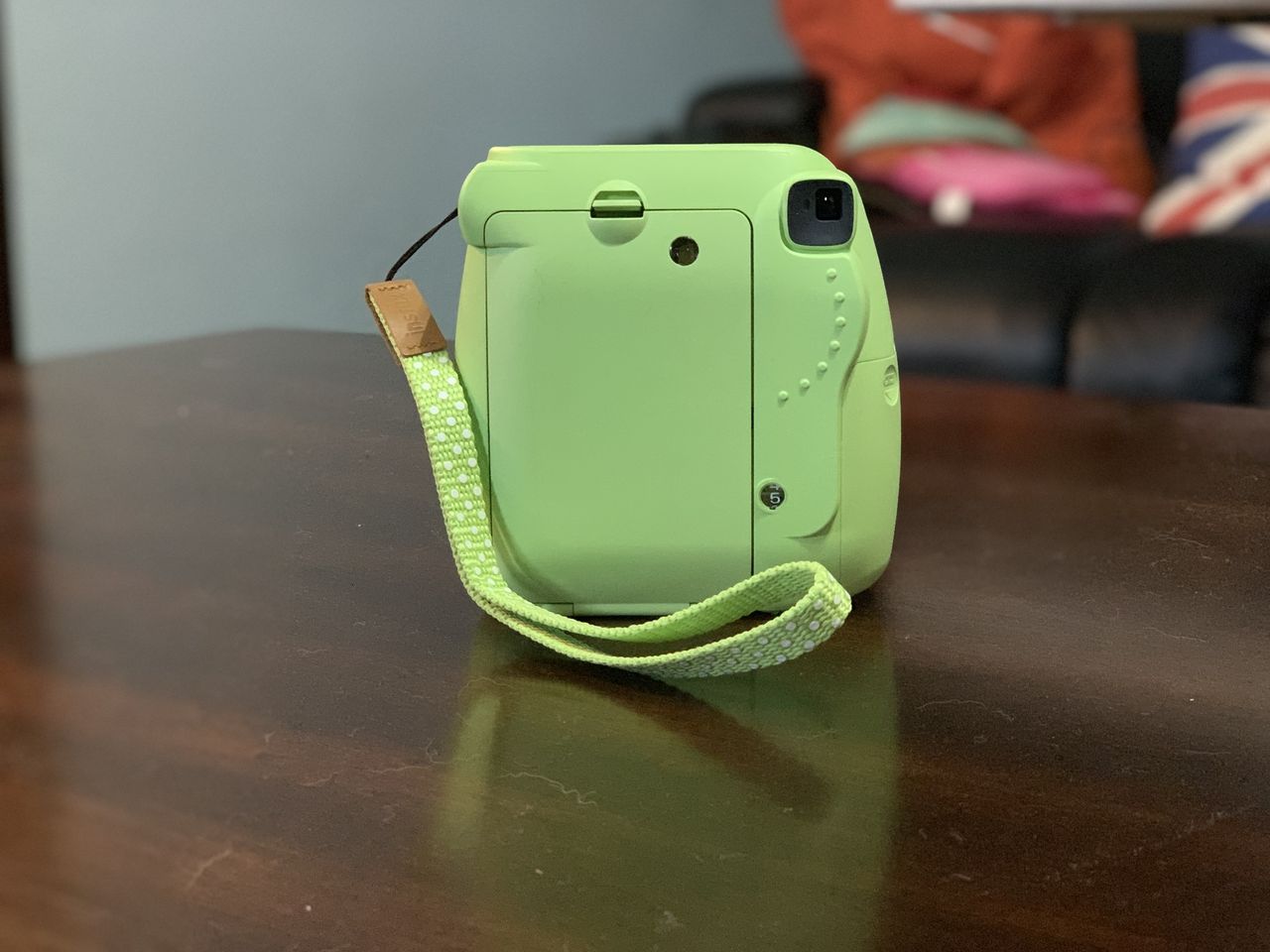 Green Fujifilm Instax Mini 9 on wood table back view