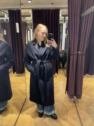 Woman wears navy long coat