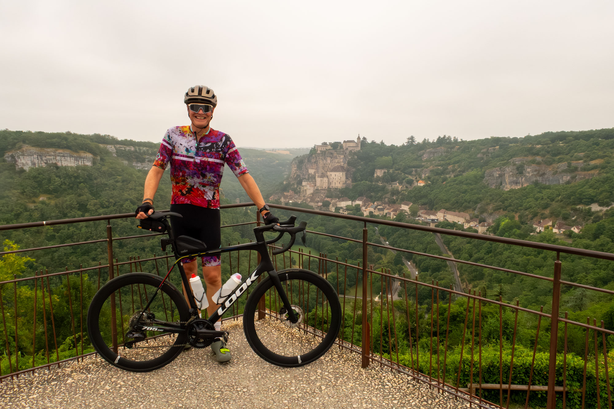 Look 785 Huez with rider, with the clifftop village of Rocamadour in the background