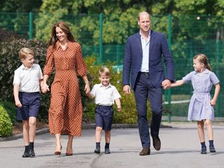 The Prince and Princess of Wales holding hands with Prince George, Princess Charlotte and Prince Louis as they enter Lambrook School