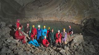 Cave explorers pose in front of an underground thermal lake in Albania.