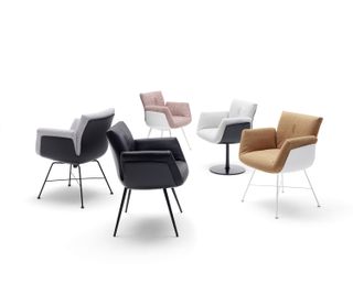 Home office chairs in different colors are set in a rough circle. Dark and light gray chairs, black, pink, and brown.