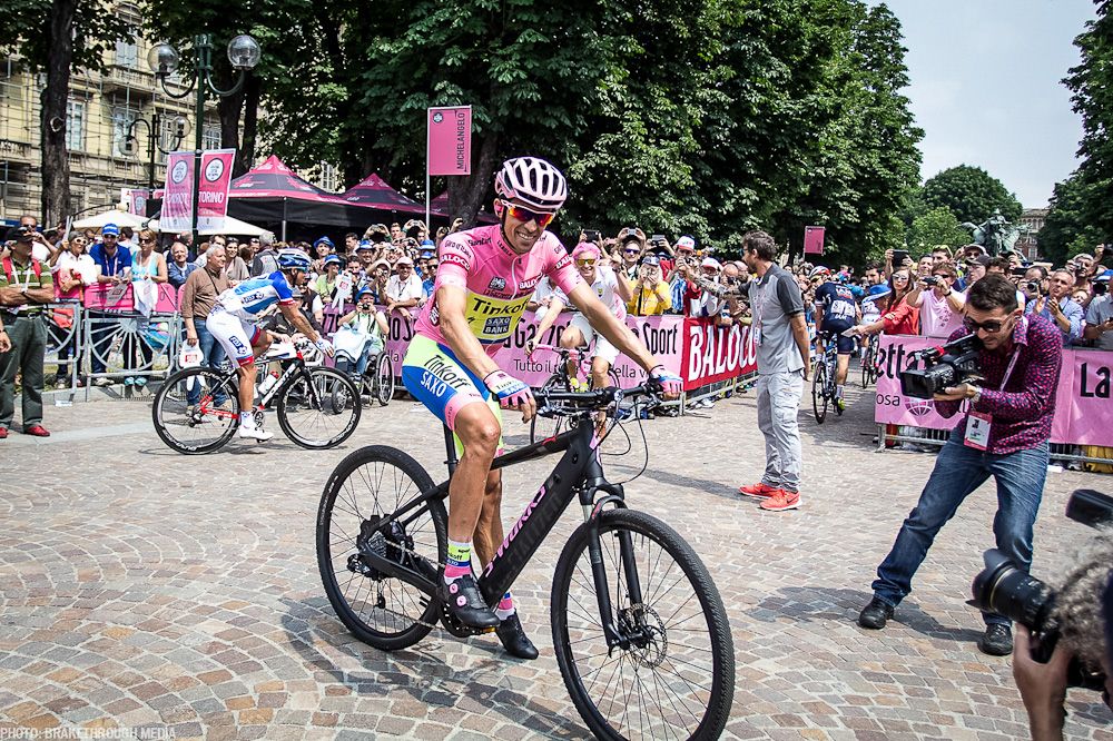 Alberto Contador hops on a different kind of two-wheeler before the start of stage 21.