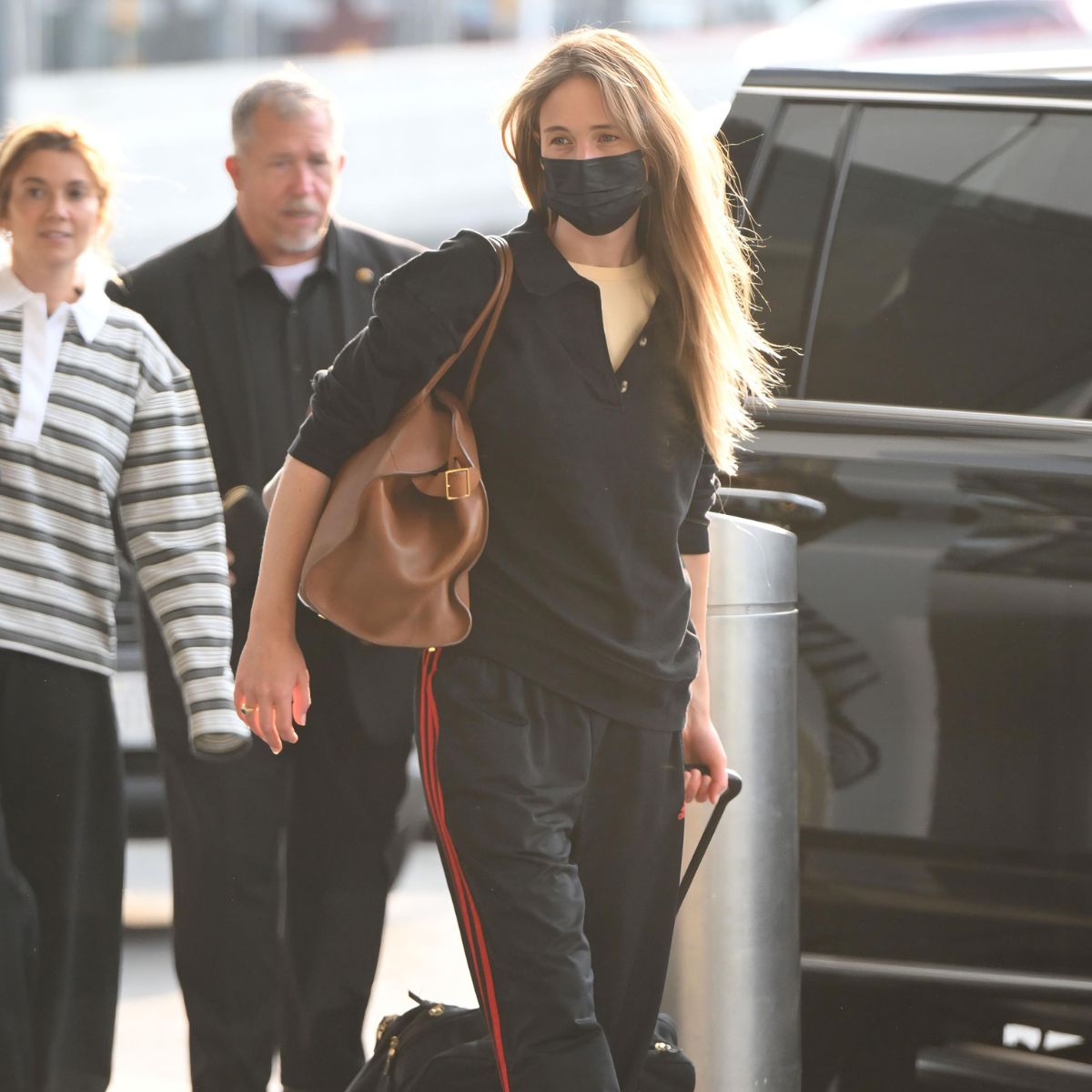 An image of Jennifer Lawrence wearing a polo with Adidas tracksuit and water shoes. 