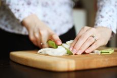 Woman chopping onions on cutting board