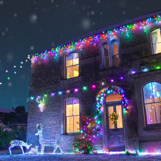 house decorated in multicoloured festive lights and reindeer