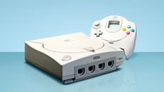 Sega Dreamcast console with controller, on blue background