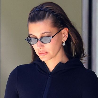 Hailey Bieber wearing neon yellow jelly Nike sneakers with a black Alo workout set