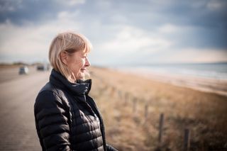 Side View Of Senior Woman Wearing Warm Clothing While Looking Away Against Sky - stock photo