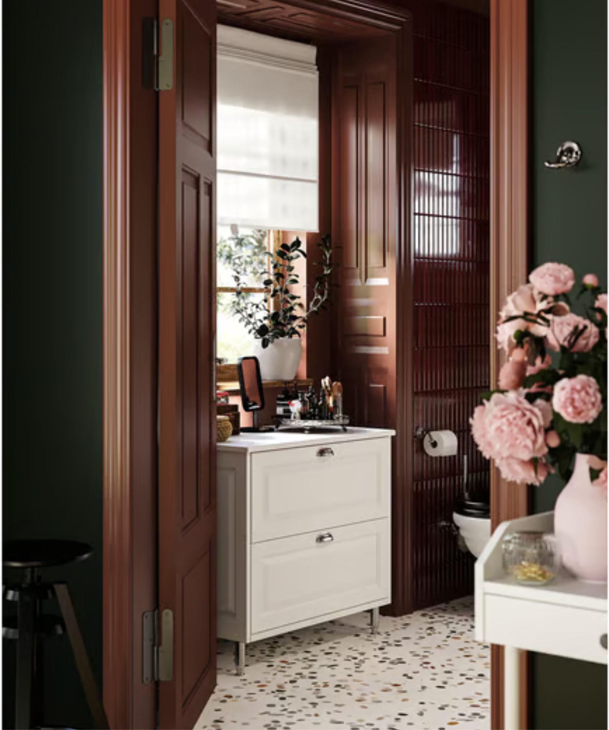 Bathroom with dark wood panelling around window, terrazzo floor, white vanity unit and white roman blind on window