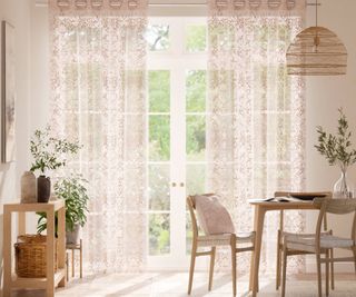 floor length cream voile curtains with strawberry print hung at patio doors in dining area of room