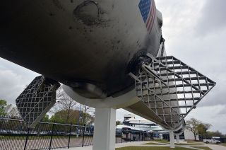 A SpaceX Falcon 9 rocket stage displays the wear and tear of having been launched twice in its newly-opened outdoor exhibit at Space Center Houston in Texas.