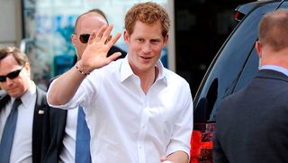 Prince Harry waves to photographers