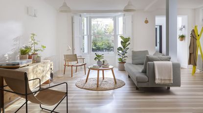 A white living room with light wooden flooring and low-seat deck style chair decor