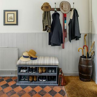 hallway with cloths on hook and shoes storage with umbrella stand