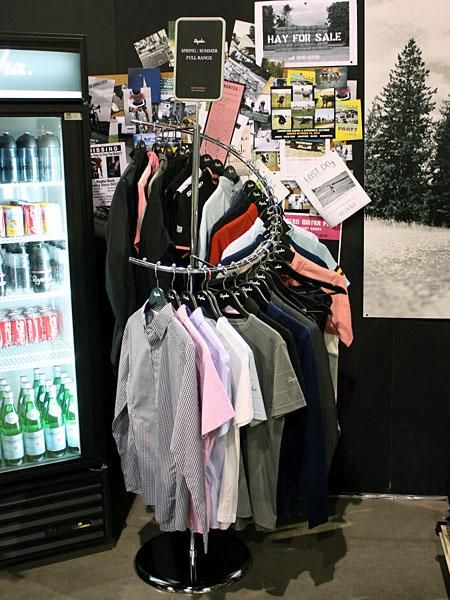A range of Rapha's new casual wear lineup is neatly displayed on a retail spiral rack.