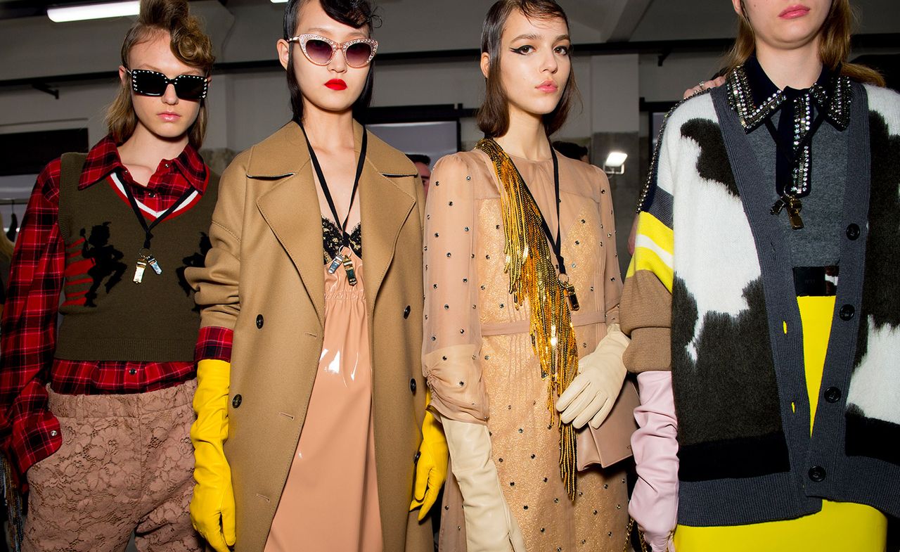 Models wear camel trench coats, knitted came cardigans and embellished shirts