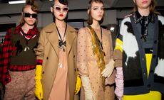 Models wear camel trench coats, knitted came cardigans and embellished shirts