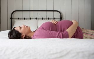 Woman-pregnant-with-twins lying down