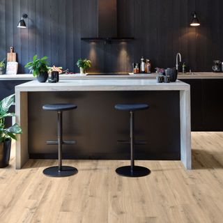 black themed kitchen with white countertop and wooden flooring
