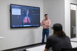 A man presents in a conference room using the new interactive display from Hall Technologies.