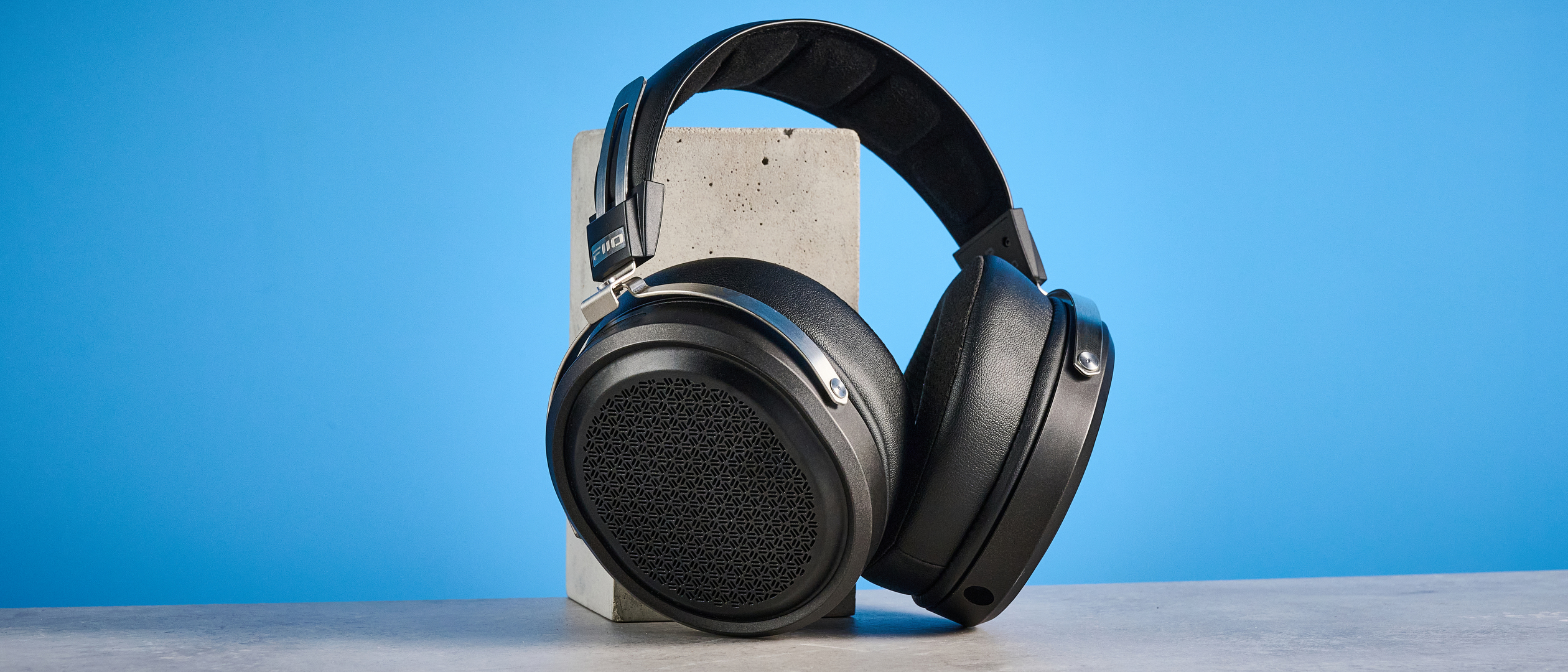 the fiio ft1 pro wired open-back headphones photographed with a blue tom's guide background