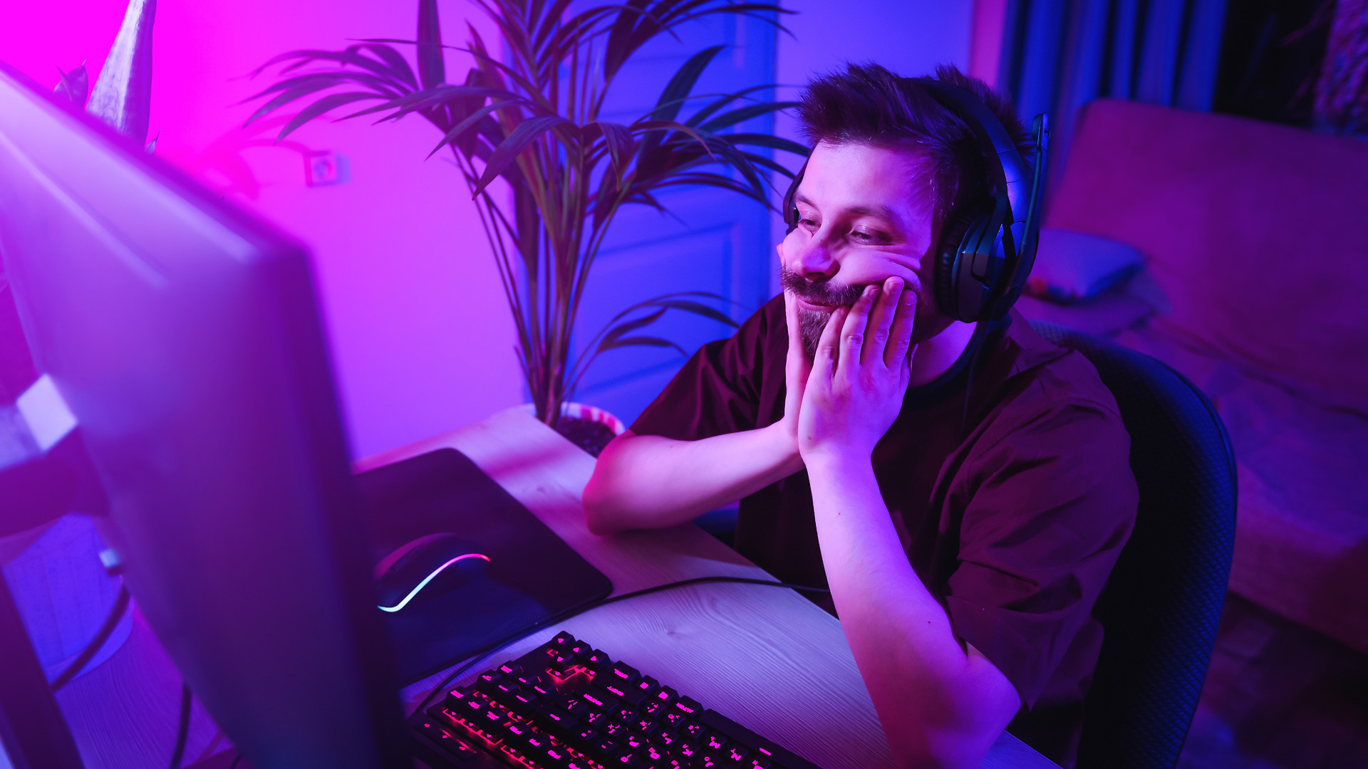 A man who looks tired and bored at his gaming computer