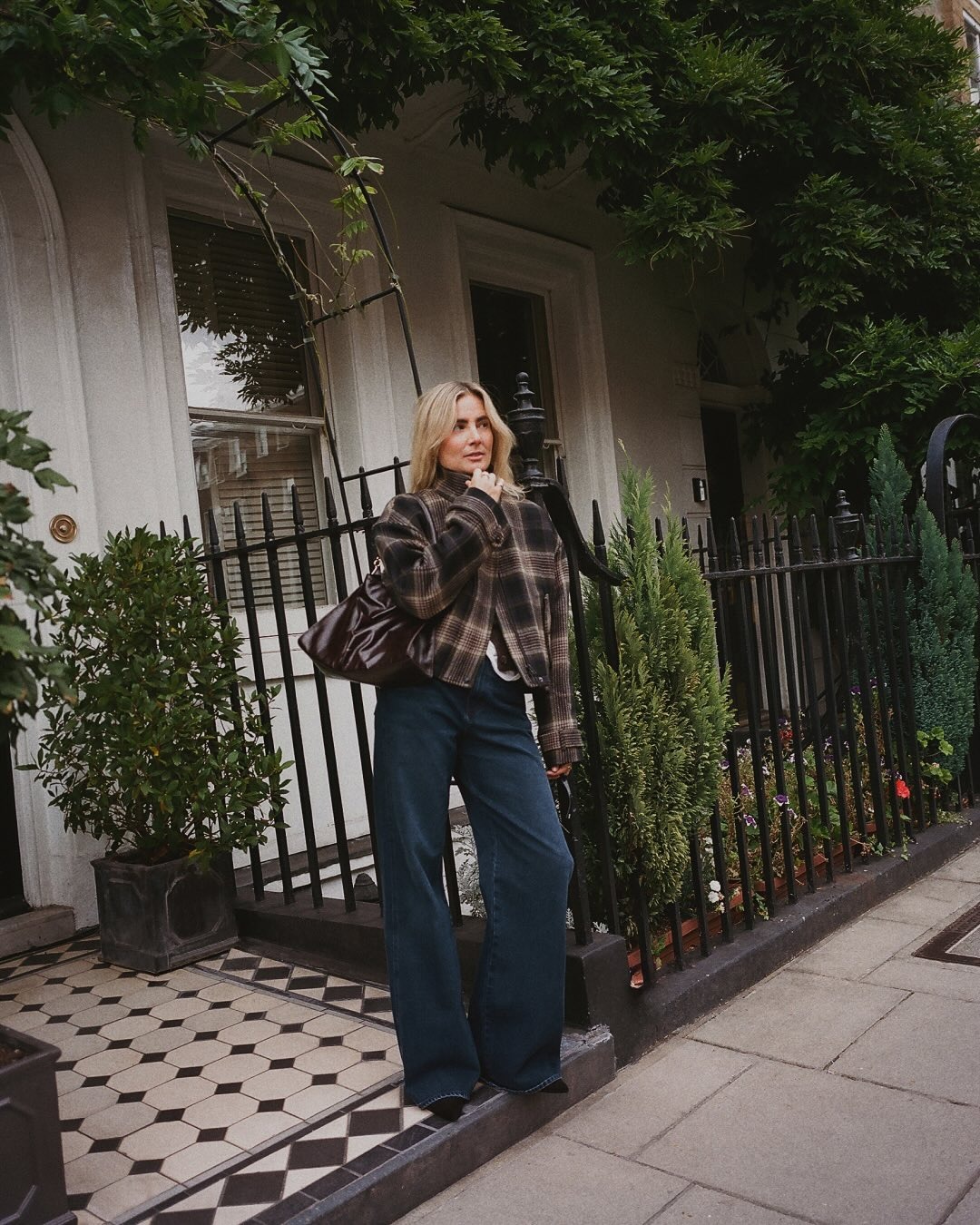 Influencer @lucywilliams02 wears dark wash jeans with a checked jacket.