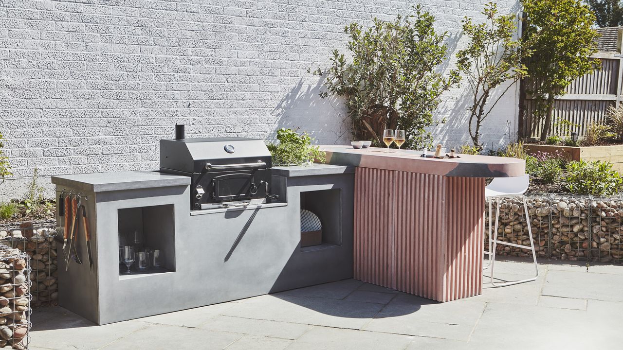 garden with outdoor kitchen with an outdoor grill and breakfast bar