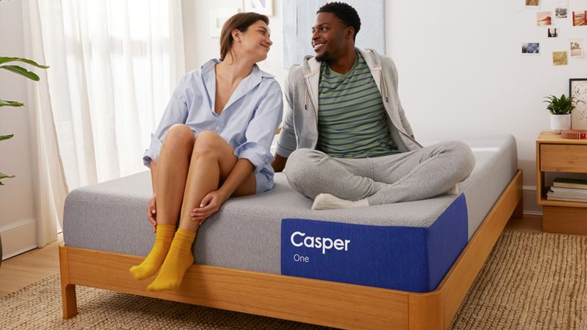 A couple sitting on the Casper One mattress