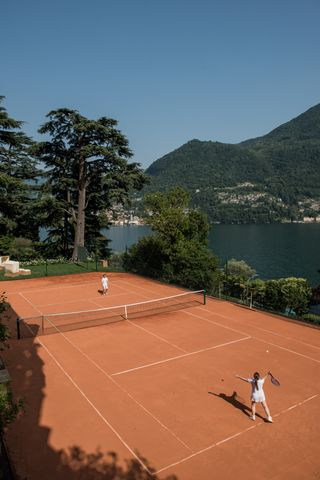 Clay tennis court overlooking lake