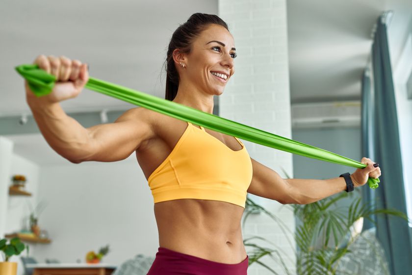 a photo of a woman stretching out a resistance band with her arms