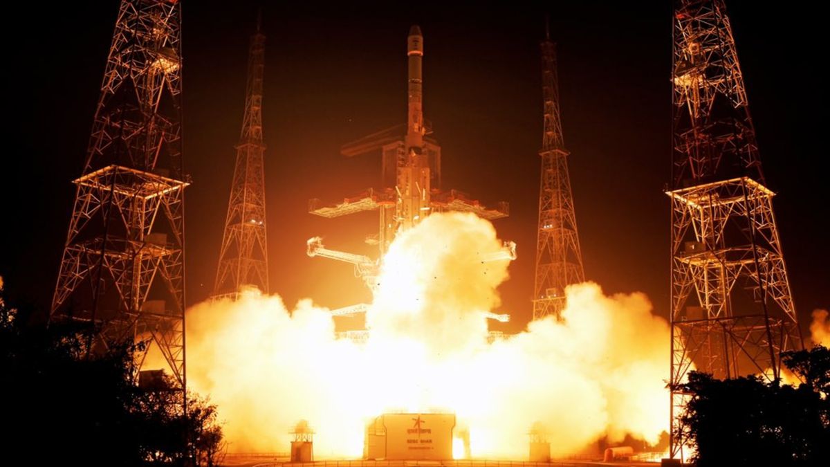 a large white rocket launches into a dark night sky