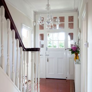 A white hallway with terracotta floor tiles
