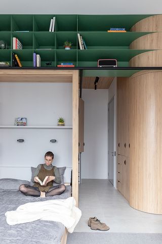 space-saving interior in Qorner tower apartment with raised shelving and fold-away bed