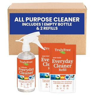 Two multi-purpose cleaning packets next to a matching spray bottle. In front of a cardboard box. 