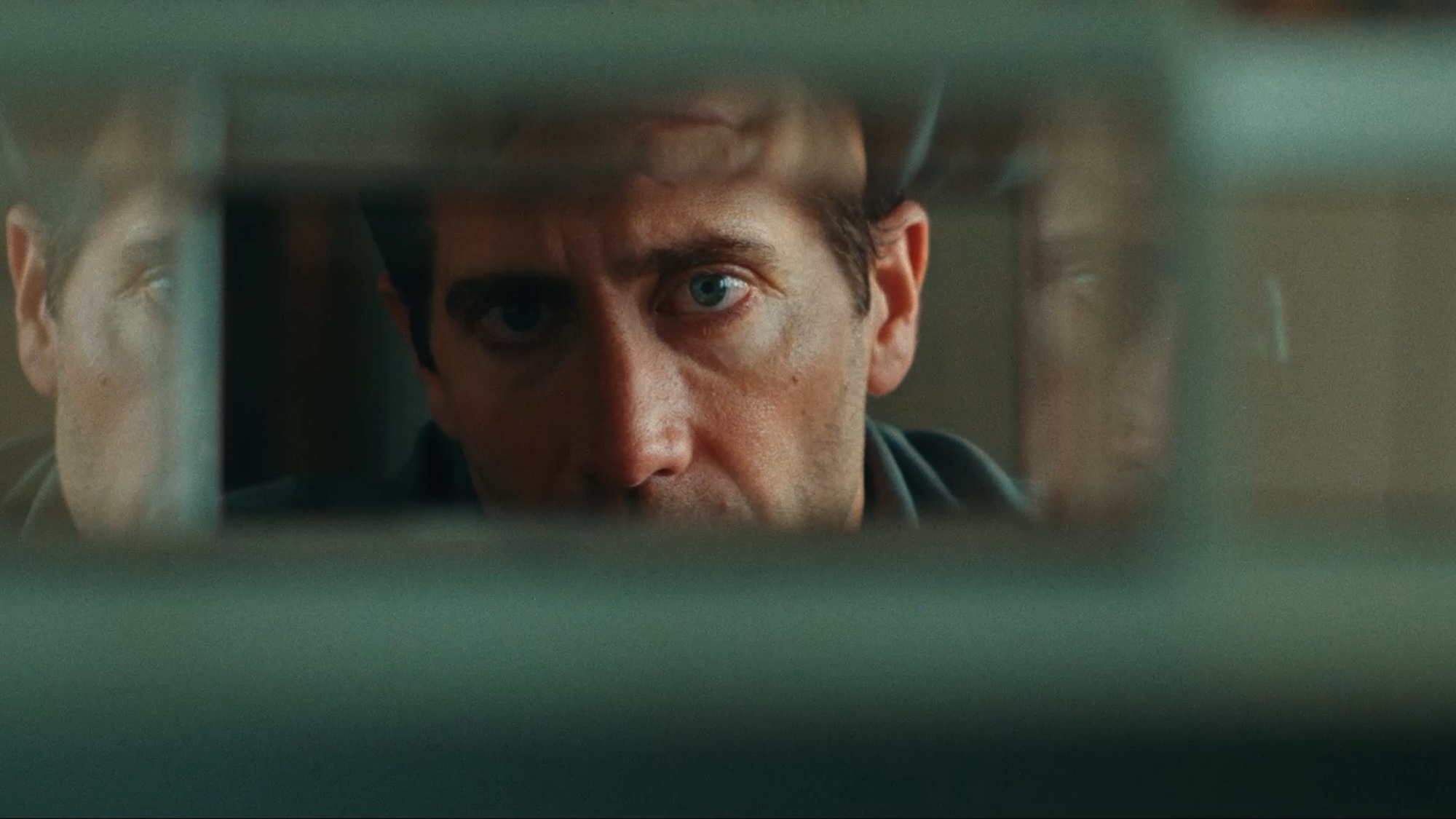 Jake Gyllenhaal peering through a model structure in Remain