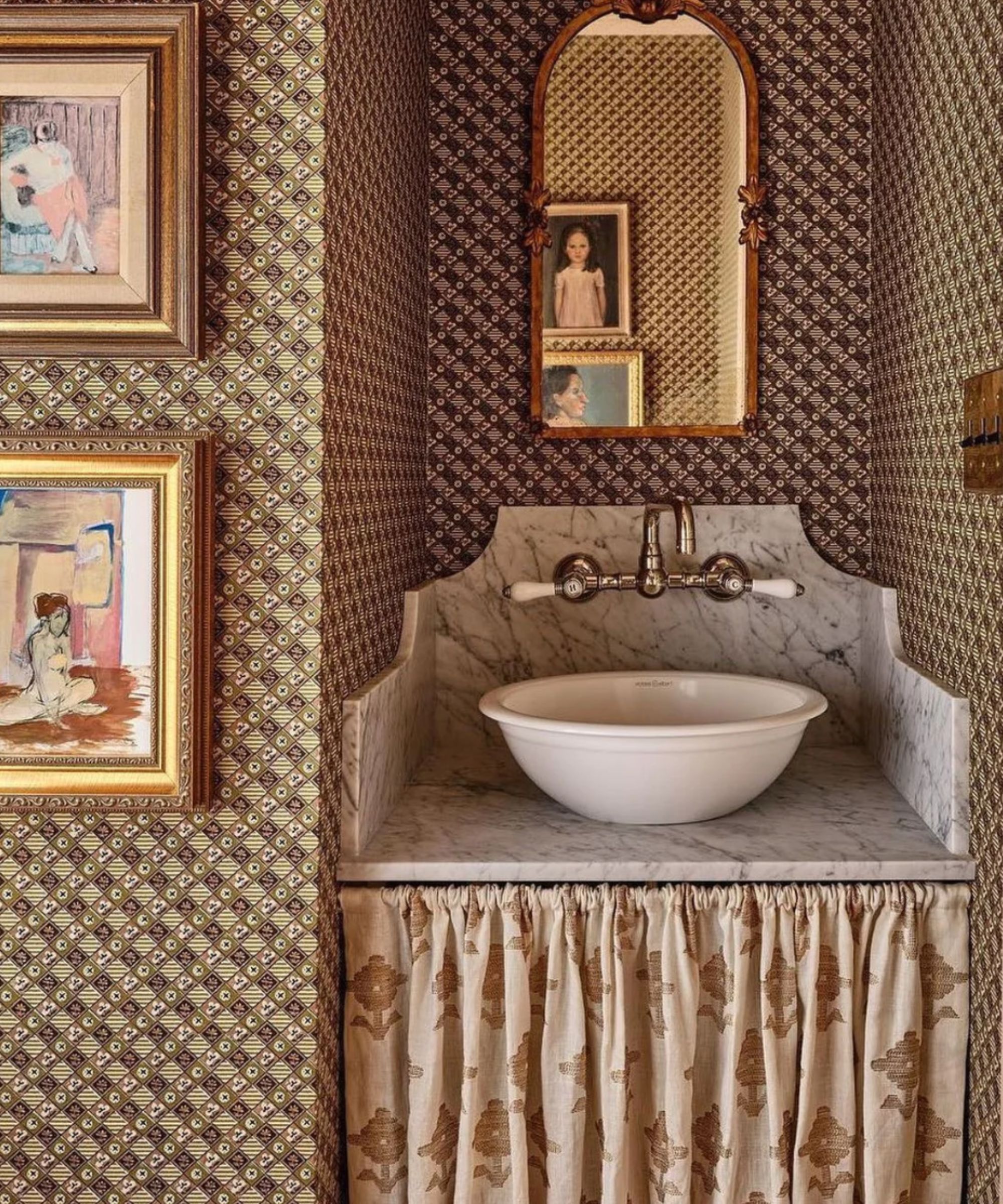A wallpapered bathroom with a skirted bathroom vanity