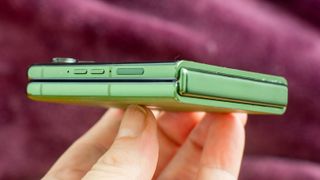 Motorola Razr Plus 2024 en vert fermé et montrant la colonne vertébrale