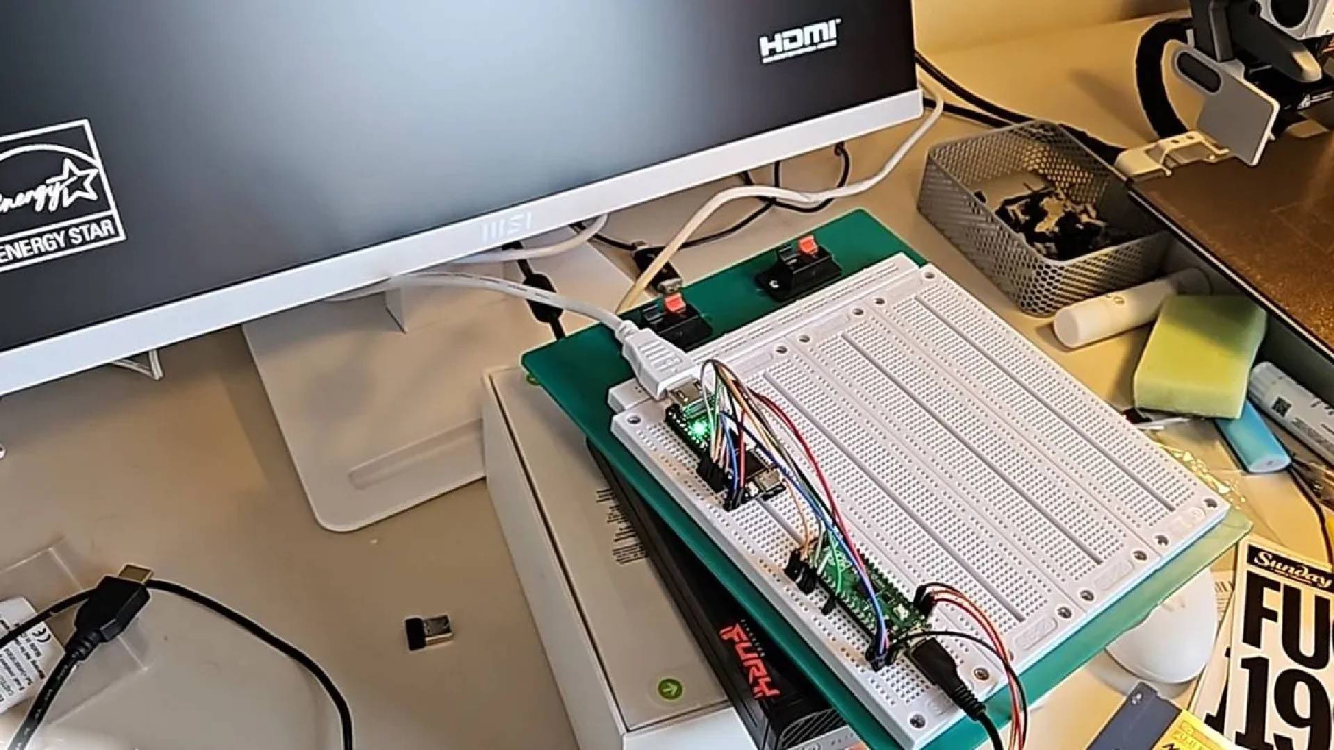 Circuit breadboards with Tang Nano FPGA chips and Raspberry Pi boards with wires attached.