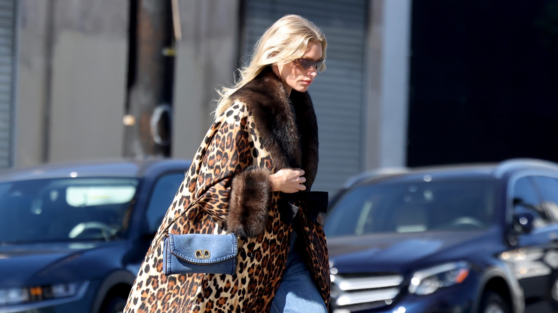 Elsa Hosk wearing a leopard coat, denim Valentino bag, jeans, and cognac pumps