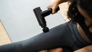 a photo of a woman using a massage gun