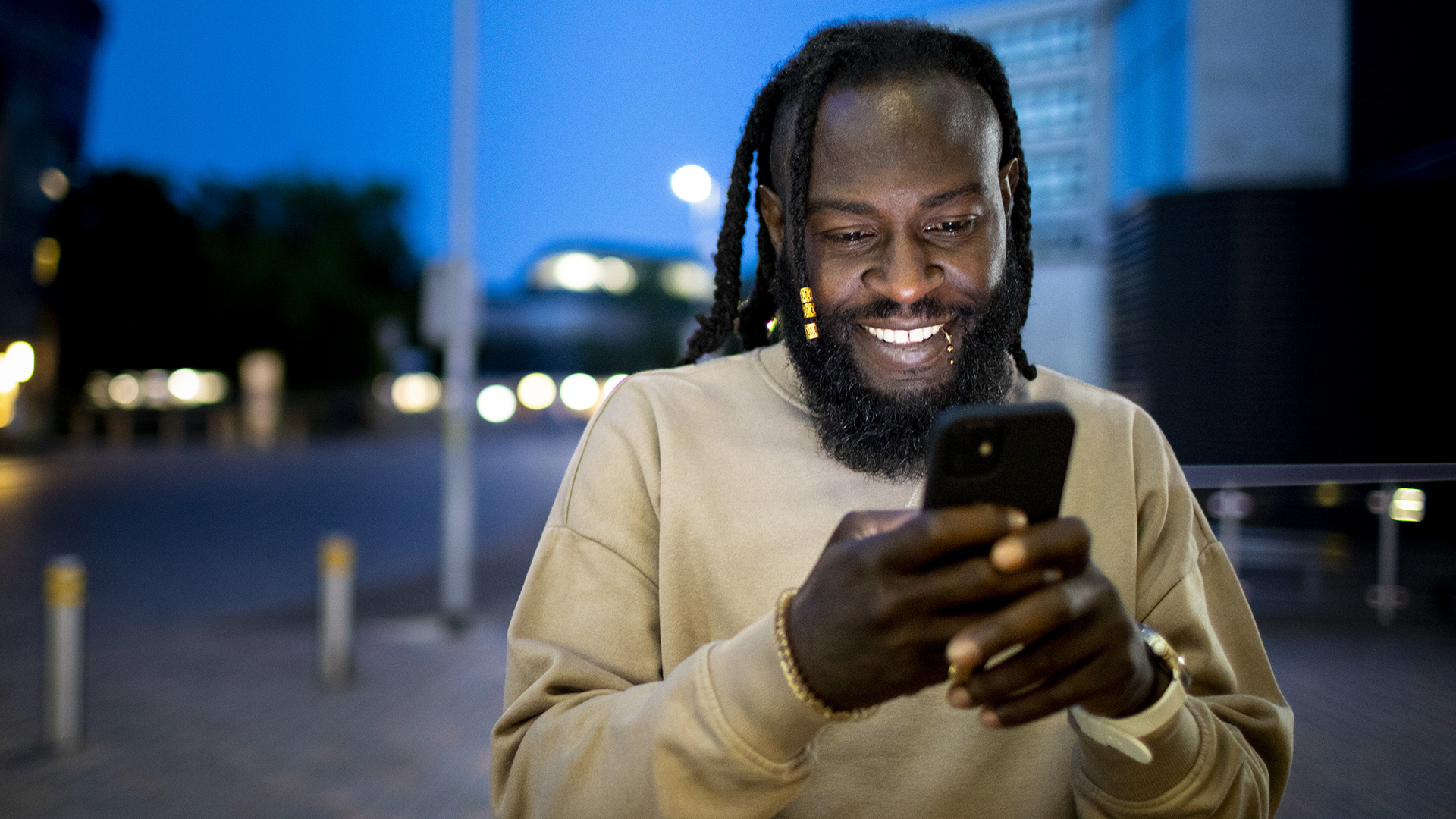 Man using phone at night on a street