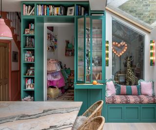 A green bookshelf fitted around a kitchen doorway