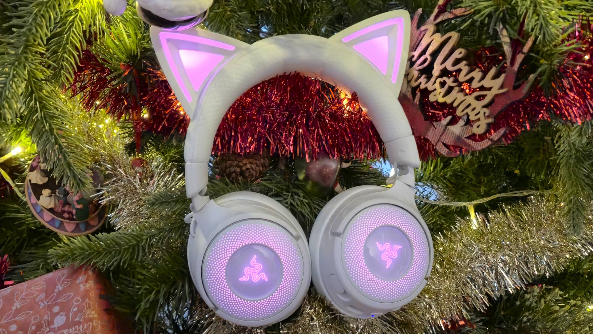 Photo of the white Kraken Kitty V3 Pro headset sitting amongst the branches of a Christmas tree.