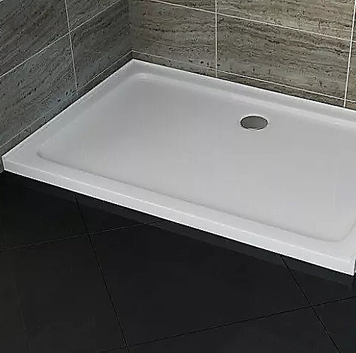 White rectangular shower tray against grey tiles and black floor